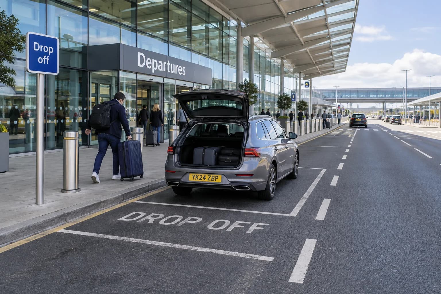 Airport terminal drop-off road with passenger unloading bays and payment signs