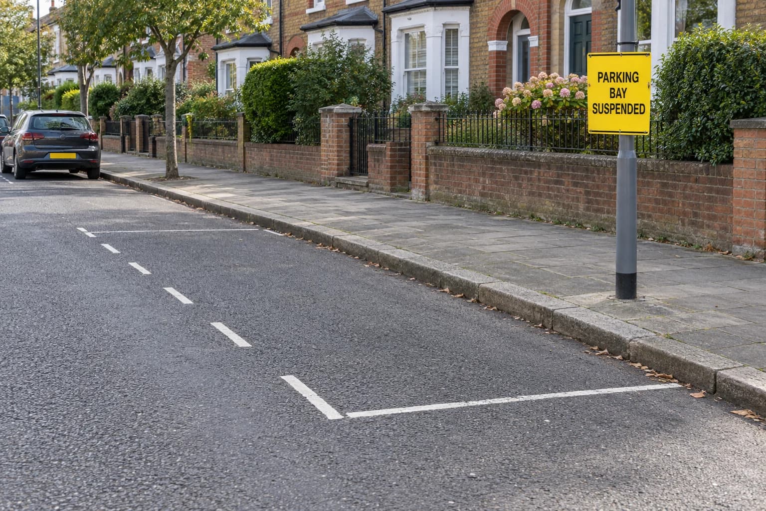 Empty on-street parking bay beside a yellow parking-bay-suspended notice.