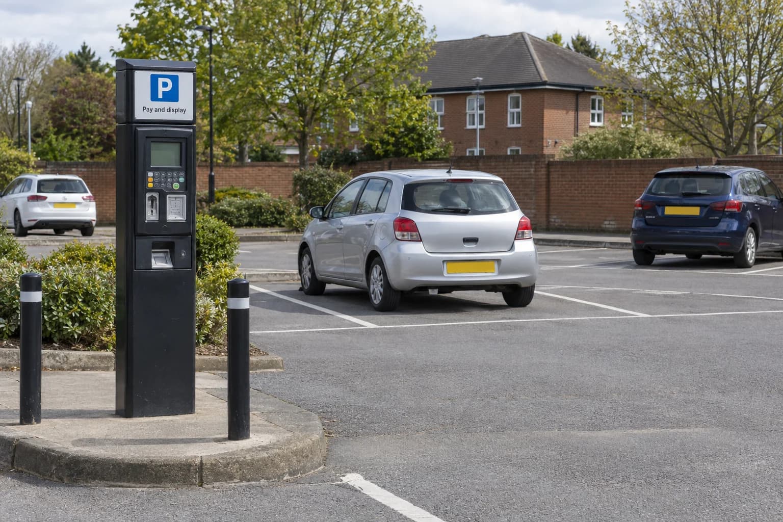 Marked bays and a pay-and-display machine in an open public-style car park.