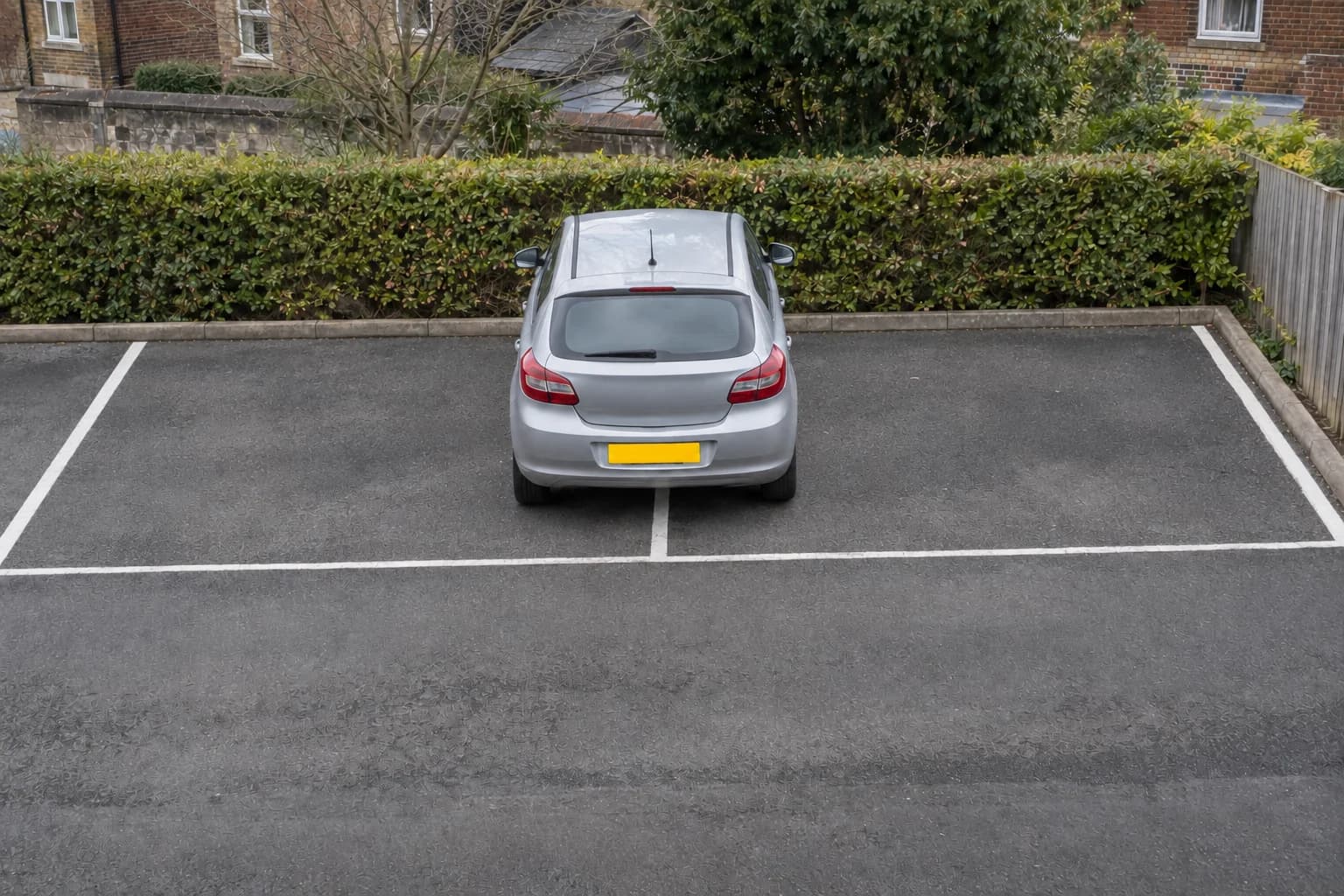 Car parked across the dividing line between two marked car-park bays.