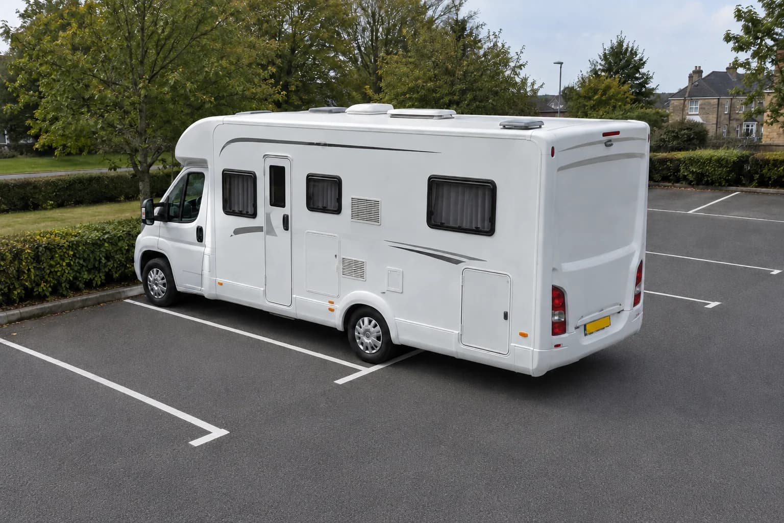 Large campervan extending beyond the end line of a marked car-park bay.