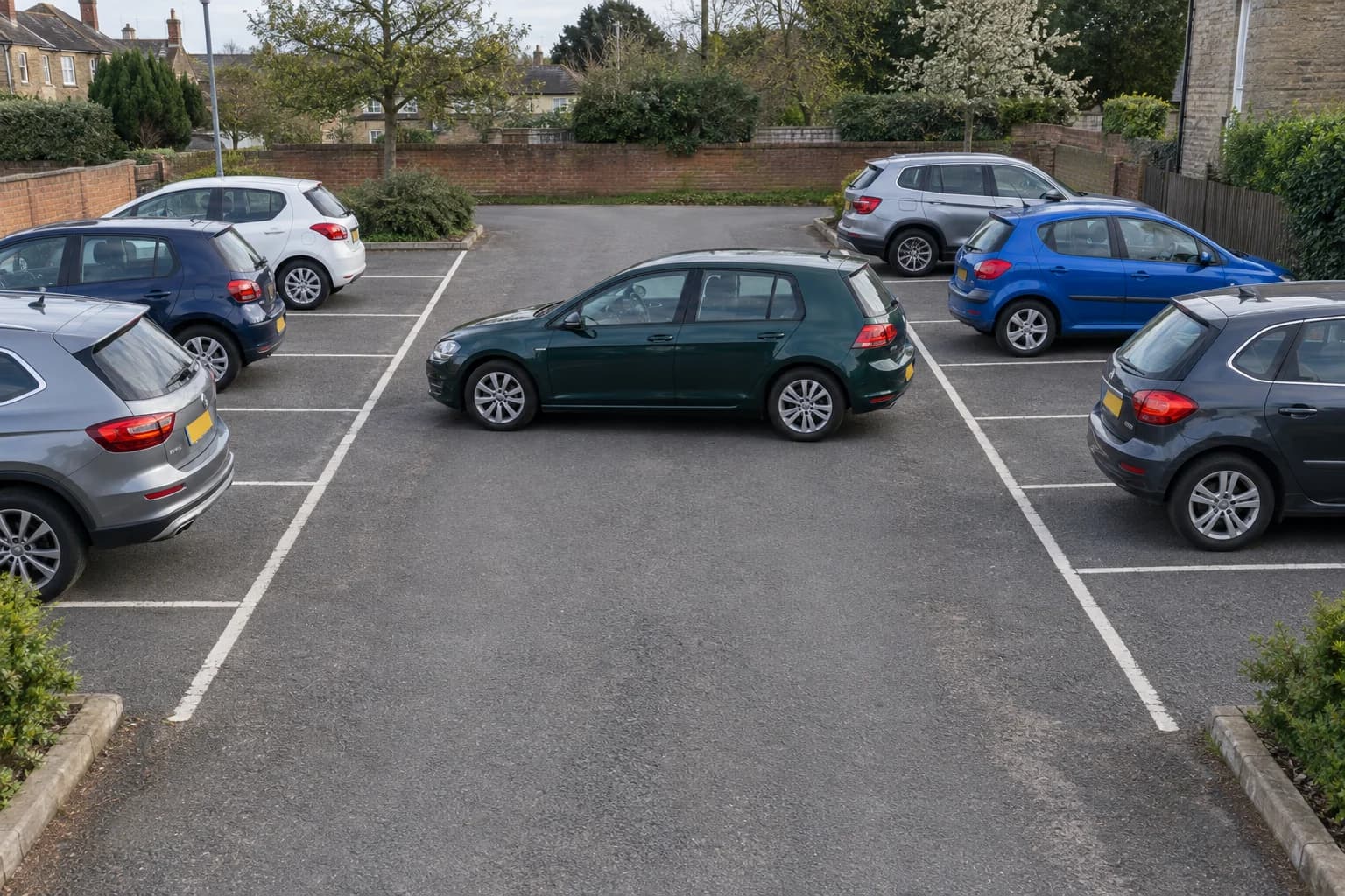 Car parked sideways across a car-park drive aisle, obstructing access between rows of bays.
