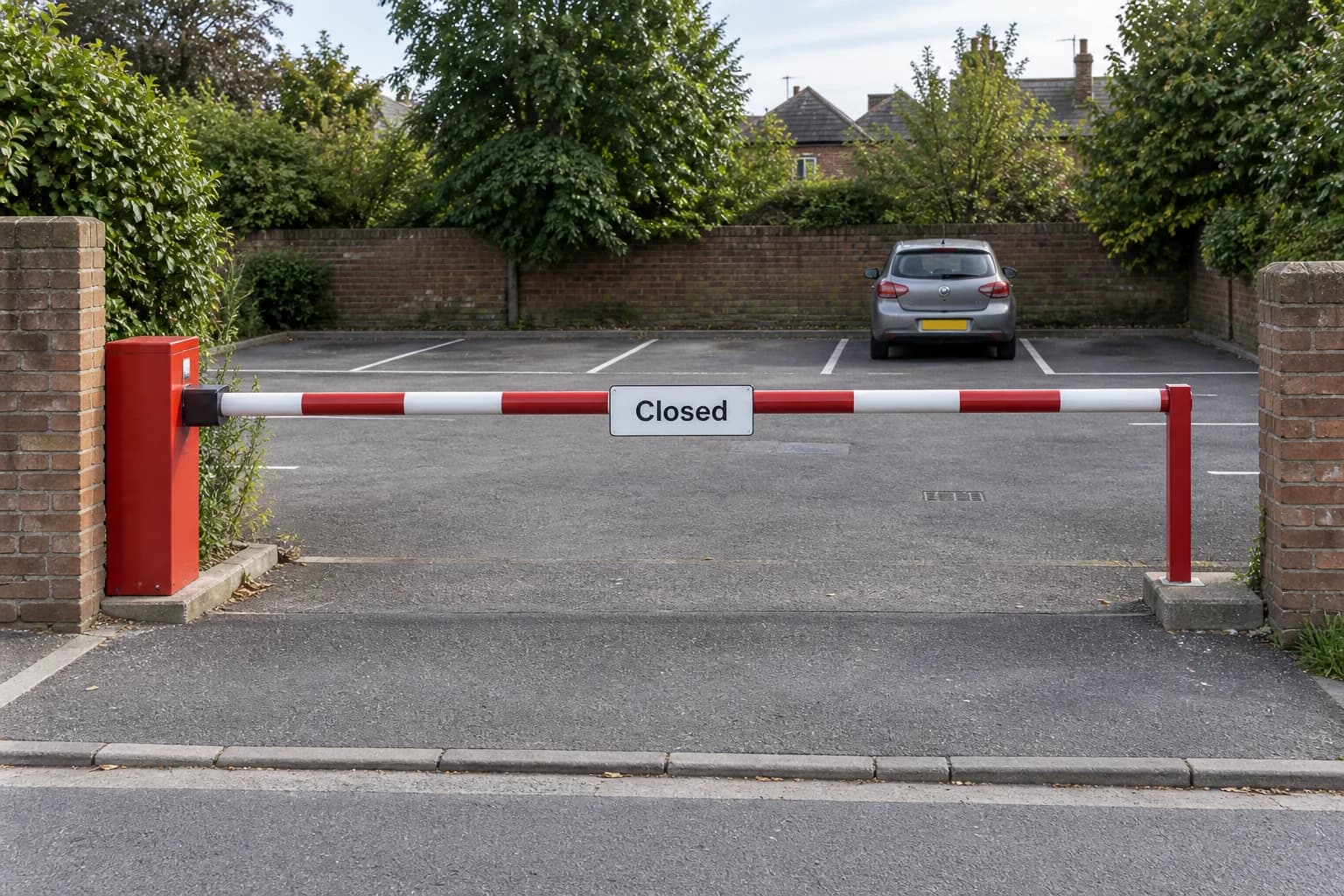 Closed car-park entrance barrier with a Closed sign and a car parked inside.